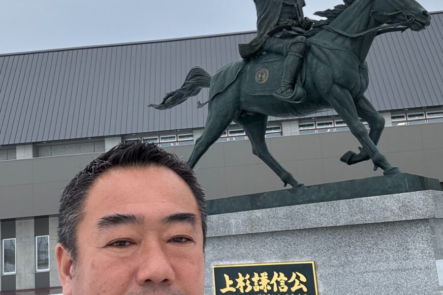 上越妙高駅の上杉謙信公の像と株式会社2moon代表伊巻のツーショット