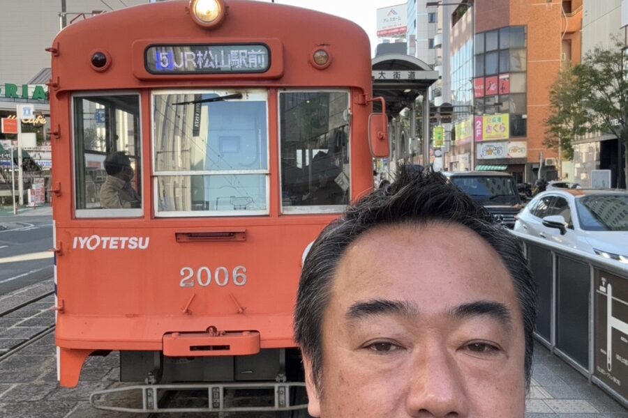 愛媛県での伊予鉄道の路面電車と株式会社2moon代表伊巻のツーショット